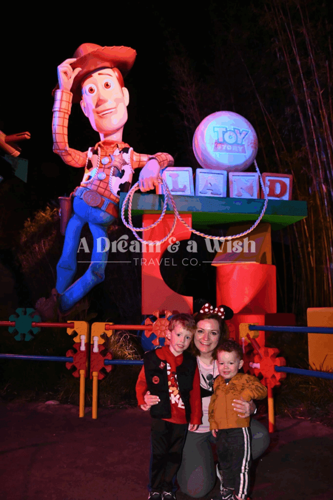 Agent smiling with her toddlers at Walt Disney World, standing in front of Toy Story Land