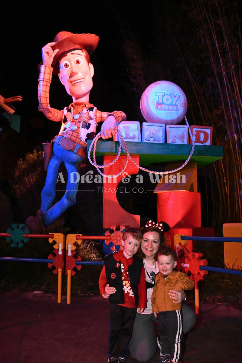 Agent smiling with her toddlers at Walt Disney World, standing in front of Toy Story Land